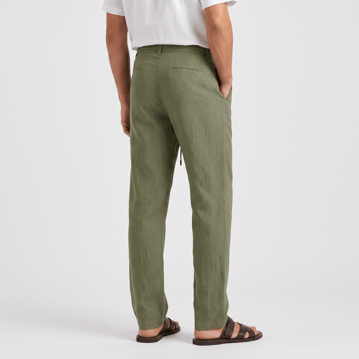 Back view of men's olive green linen drawstring pants with a straight-leg silhouette and elastic waistband.