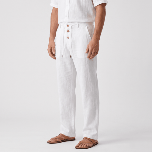 Side view of men's white linen drawstring pants featuring a relaxed straight-leg silhouette, button-front detail, and elastic waistband.