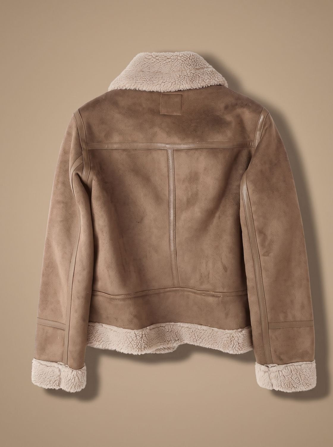 Taupe belted shearling aviator jacket for women shown from the back with plush lining and wide collar