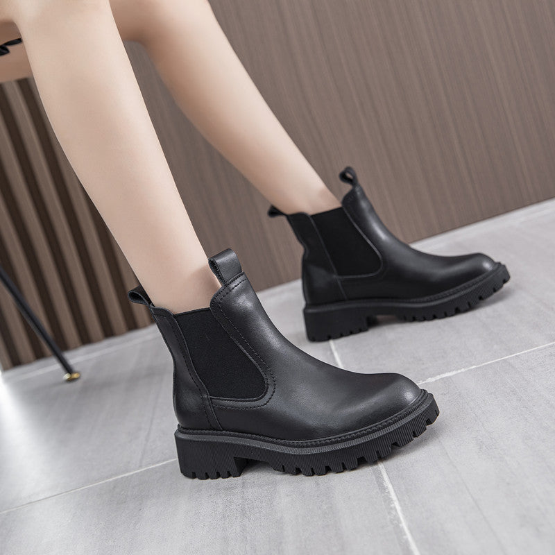 Woman wearing black leather block heel Chelsea boots with bare legs, showing the block heel height