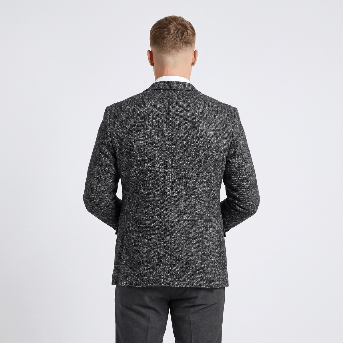 Back view of a men's charcoal gray tweed blazer with a textured finish, tailored silhouette, and classic blazer construction.