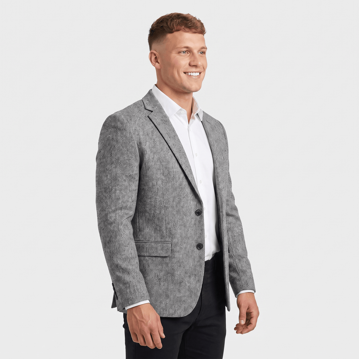 Side view of a man wearing a light gray tweed blazer with a notched lapel and tailored silhouette.