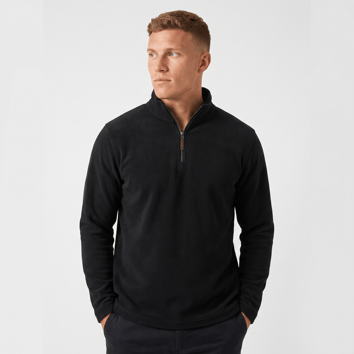Man wearing a black quarter-zip knit sweater with a stand collar, long sleeves, and a tailored fit.