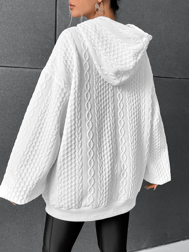 White oversized cable knit hoodie for women shown from the back, featuring a hood and textured knit pattern