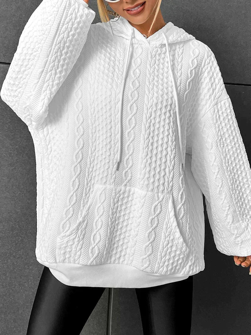 White oversized cable knit hoodie for women shown from the back, highlighting the hood, long sleeves, and textured knit pattern