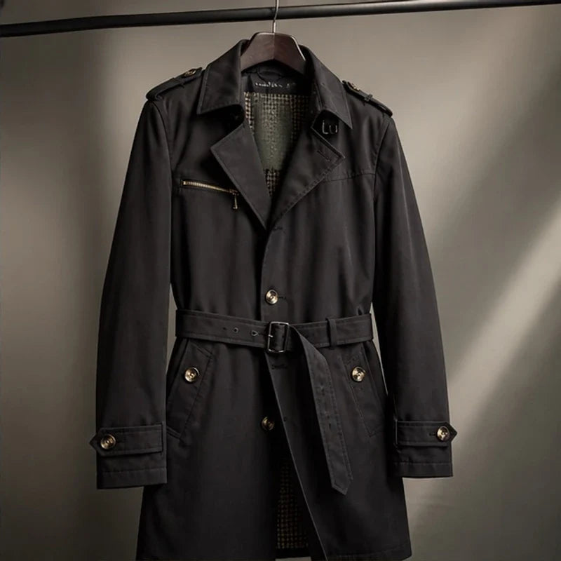 A black cotton blend trench coat with a belted waist, double-breasted front, and structured collar, shown flat