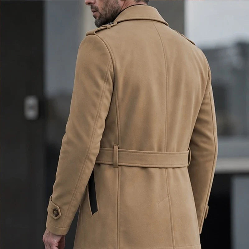 A man wearing a camel cotton blend trench coat with a belted waist, shown from the back