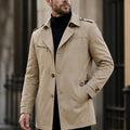 A man wearing a beige cotton blend trench coat with a belted waist and structured collar