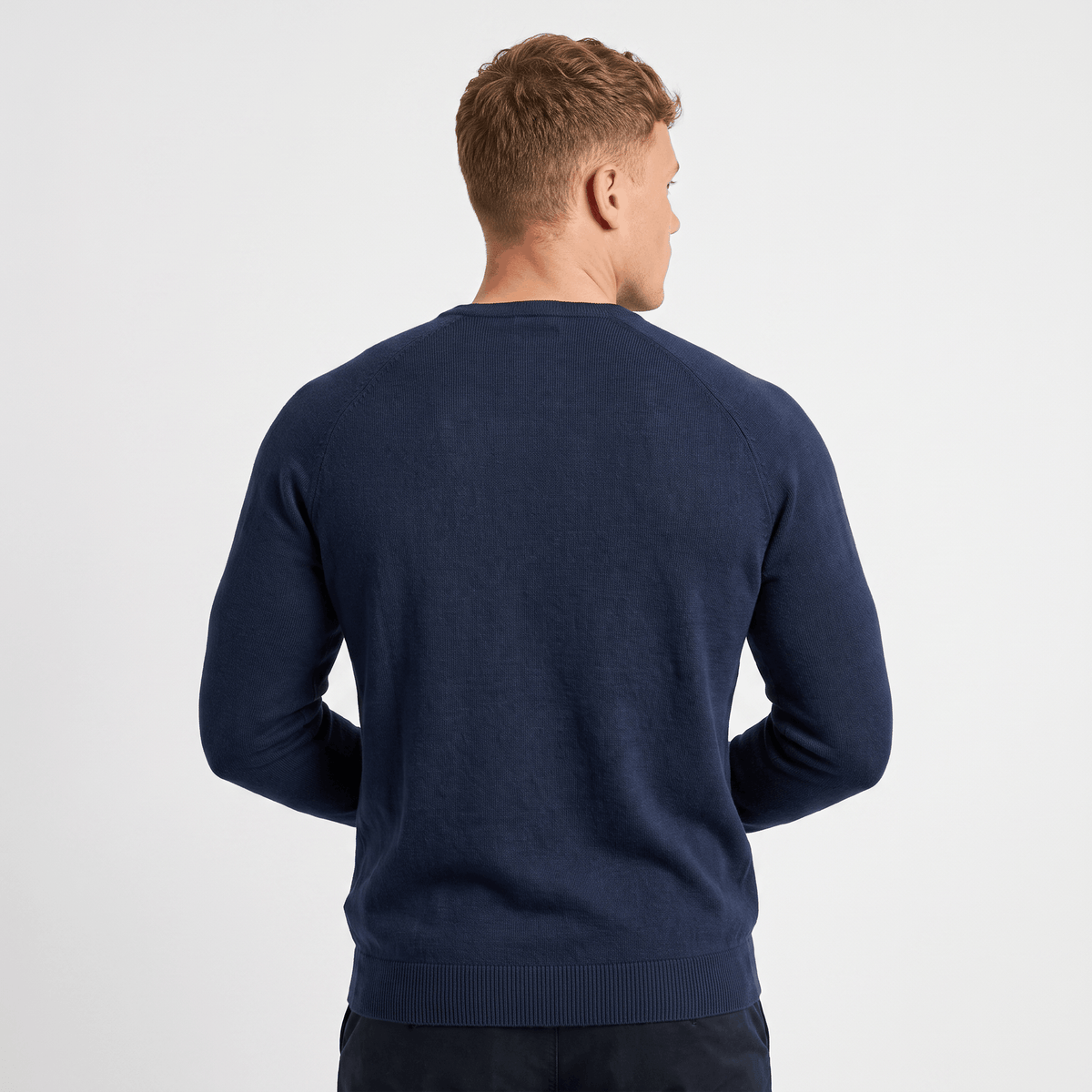 Back view of a men's navy waffle knit Henley sweater with textured knit fabric and ribbed trim.