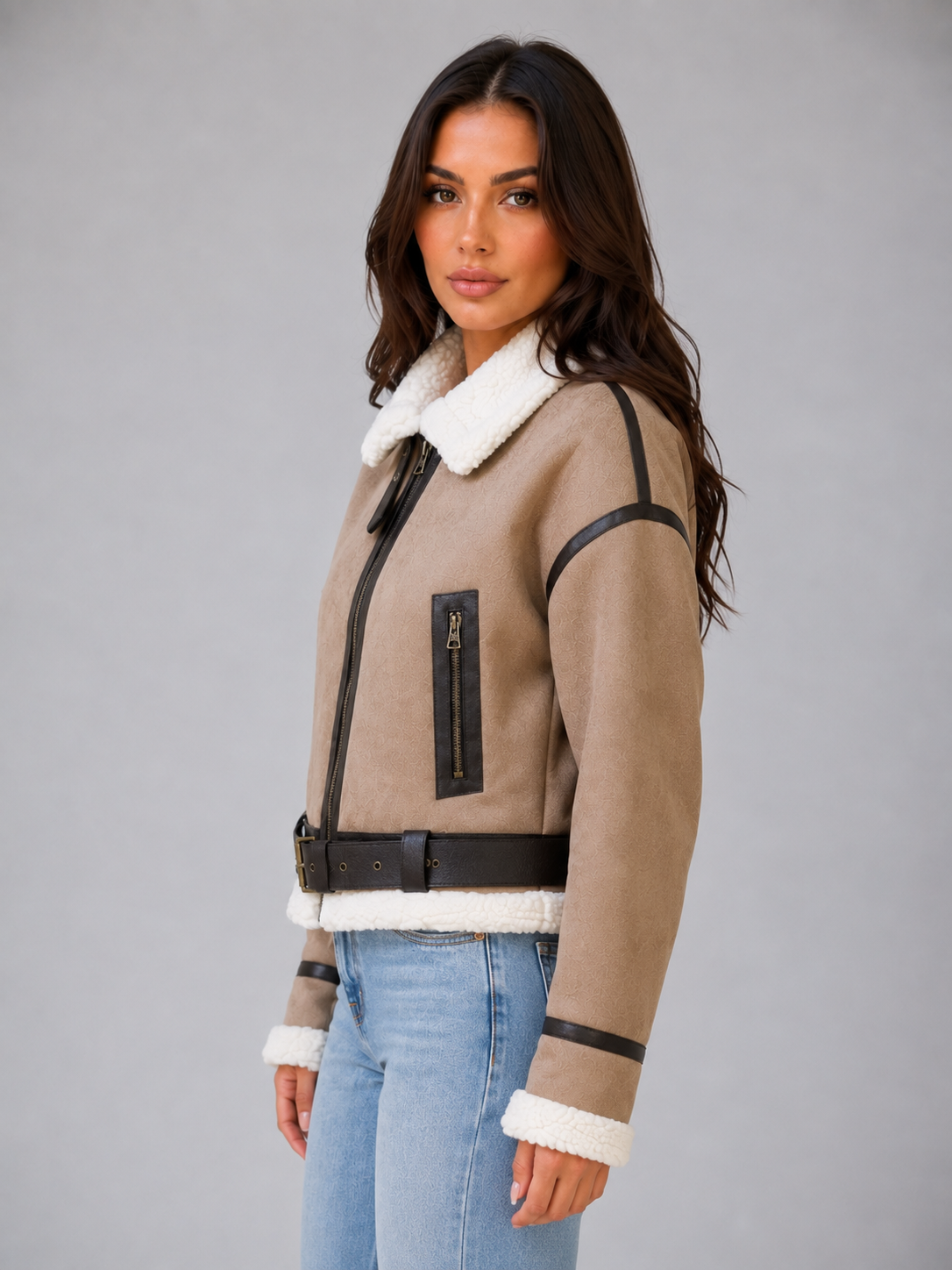 Beige cropped shearling aviator jacket for women worn by a female model, side view with teddy lining and zip pockets