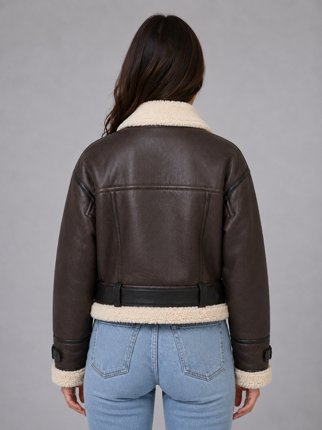 Dark brown cropped shearling aviator jacket for women worn by a female model, back view with teddy lining