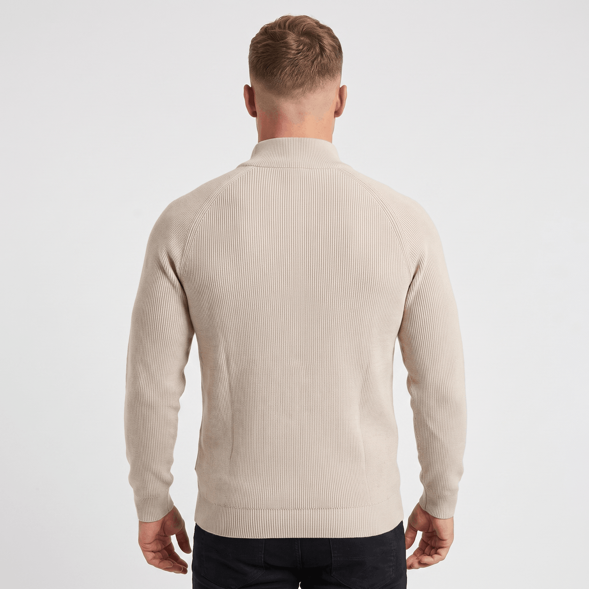 Back view of a men's cream ribbed quarter-zip knit sweater with a stand collar and vertical ribbed texture.