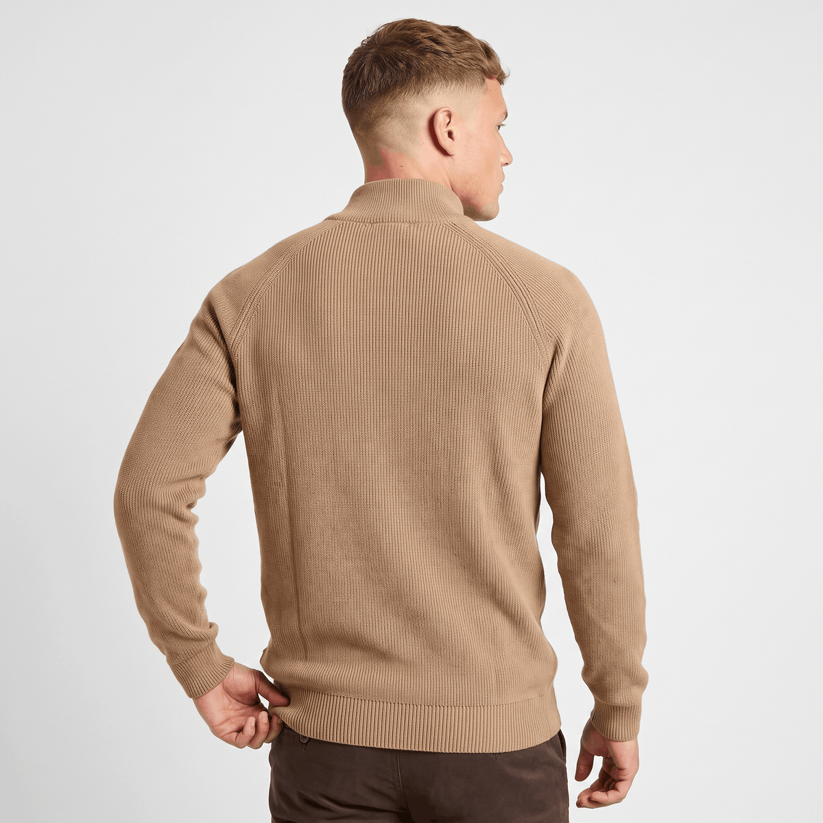 Back view of a men's camel ribbed quarter-zip knit sweater featuring a stand collar and fitted silhouette.