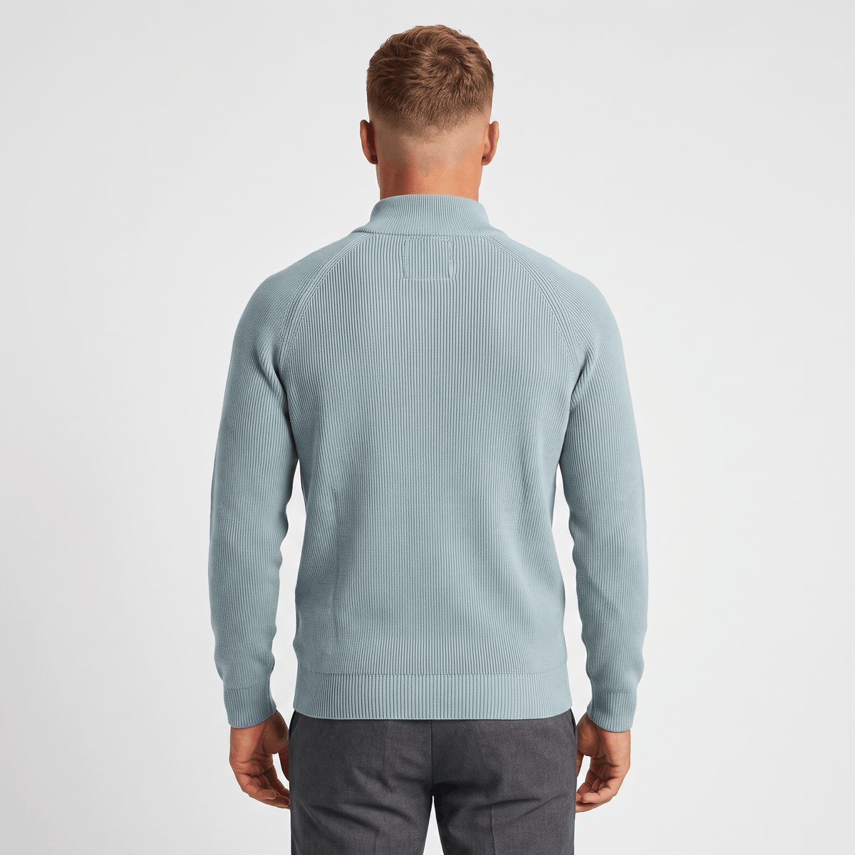 Back view of a men's light blue ribbed quarter-zip knit sweater featuring a stand collar, ribbed texture, and classic fit.