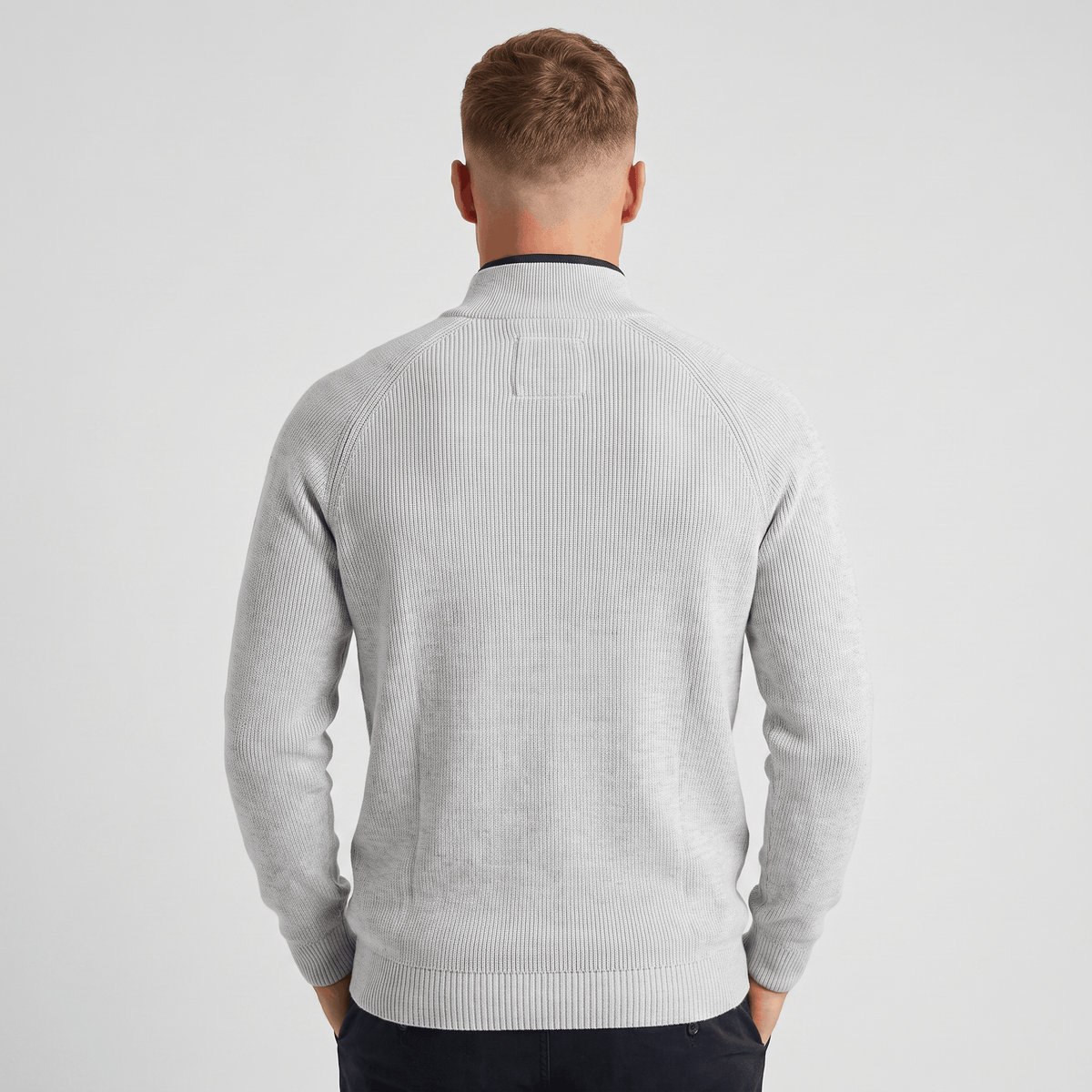 Back view of a men's light gray ribbed quarter-zip knit sweater with a stand collar and vertical ribbed texture.