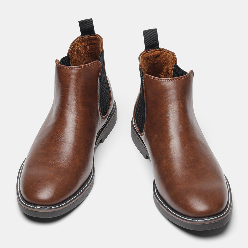 Distressed brown leather Chelsea boots with black elastic side panels, back pull loops, and a white stitched welt sole.