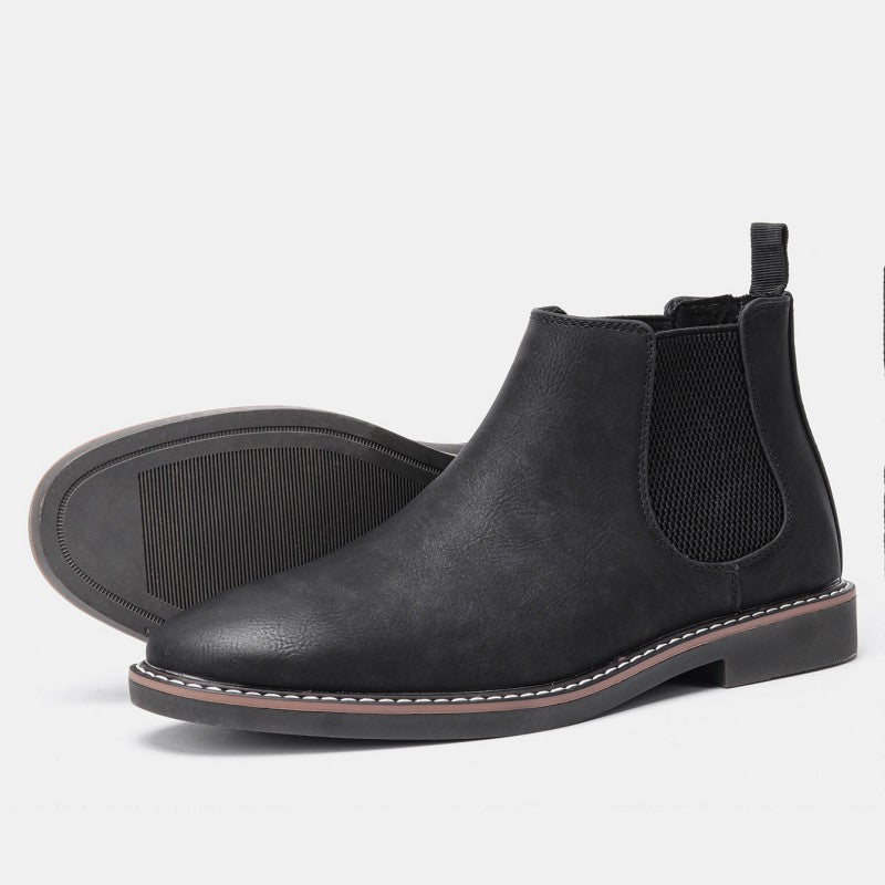 Black distressed leather Chelsea boots with elastic side panels, a stitched welt sole, and a back pull-on loop.