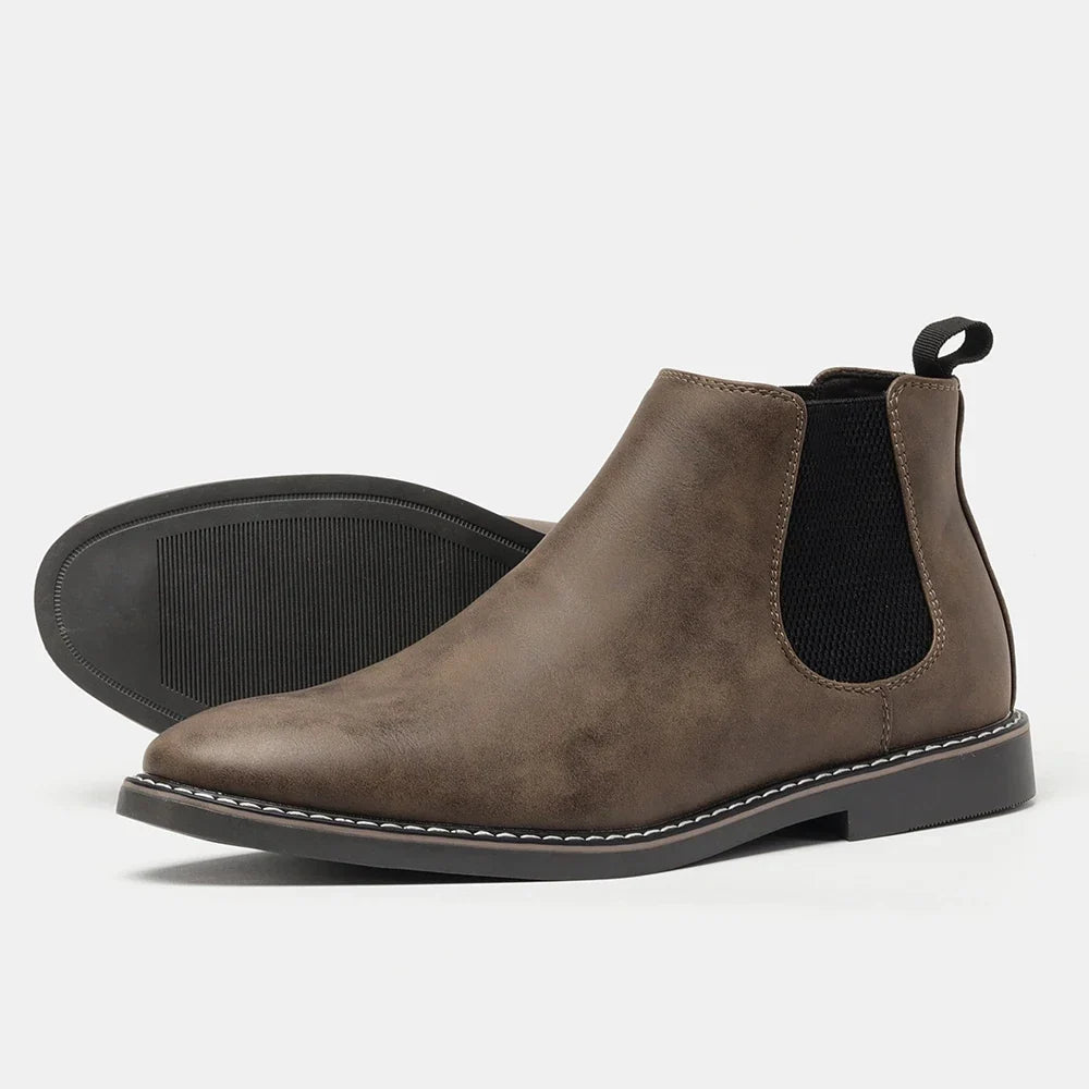 Distressed dark brown leather Chelsea boots with black elastic side panels, a back pull loop, and a white stitched welt sole.