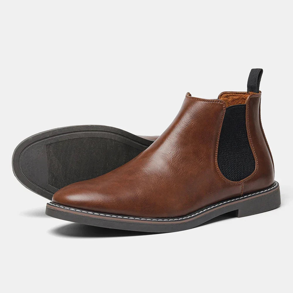 Distressed brown leather Chelsea boots with black elastic side panels, back pull loops, and a stitched welt sole.