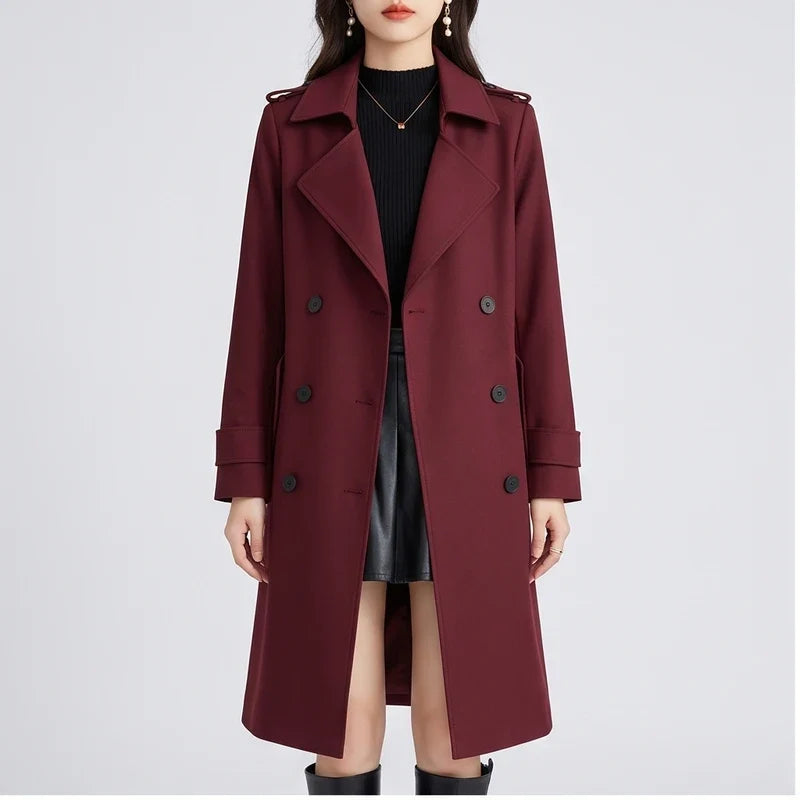 A woman wearing a burgundy double-breasted trench coat with a tailored fit and turn-down collar, front view