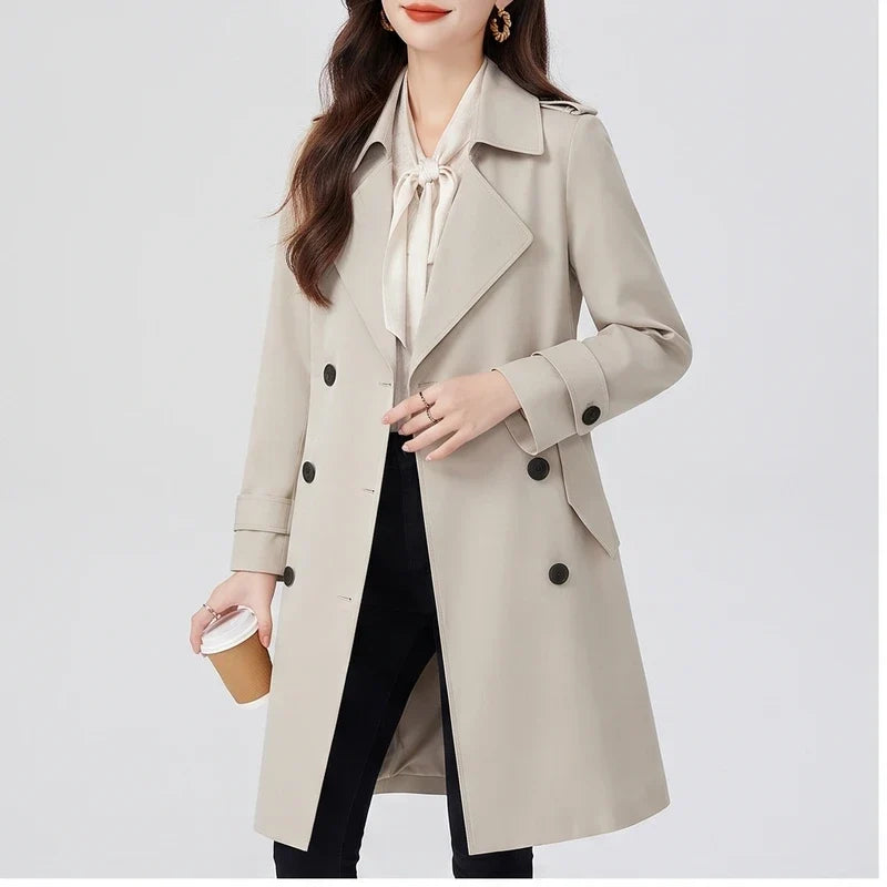 A woman wearing a cream double-breasted trench coat with a tailored fit and turn-down collar