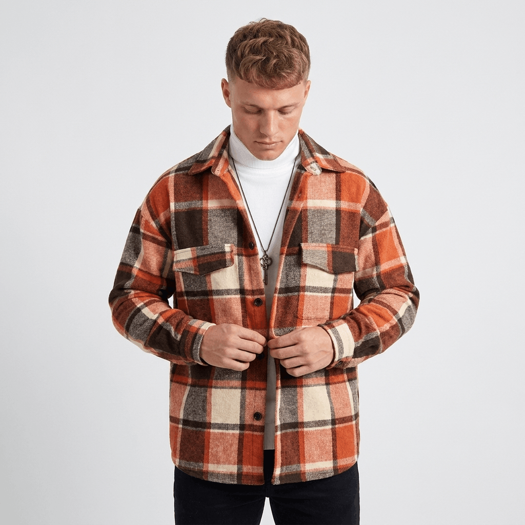 Man wearing a red, brown, and white plaid overshirt jacket with a button-front closure and chest pockets.