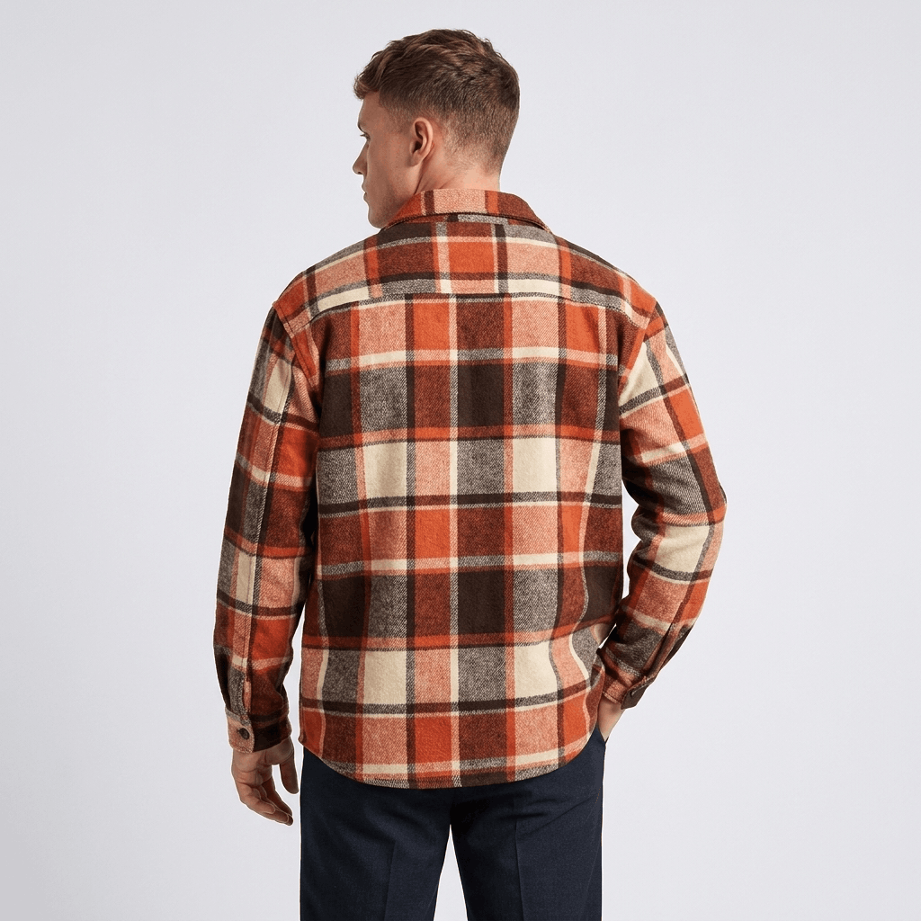 Back view of a man wearing a red, brown, and white plaid overshirt jacket with a relaxed fit and long sleeves.