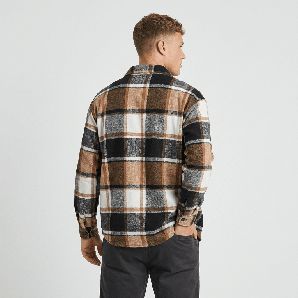 Back view of a man wearing a tan, brown, and black plaid overshirt jacket with a relaxed fit and long sleeves.