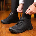 Black fleece-lined lace-up winter boots with rugged lug soles, worn with black pants indoors