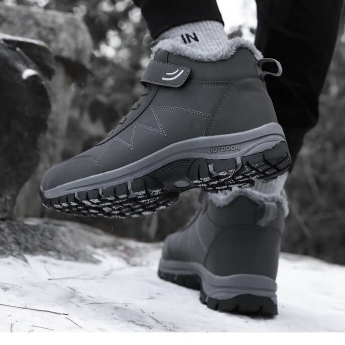Black fleece-lined winter hiker boot with a hook-and-loop strap and rugged anti-slip sole, shown outdoors