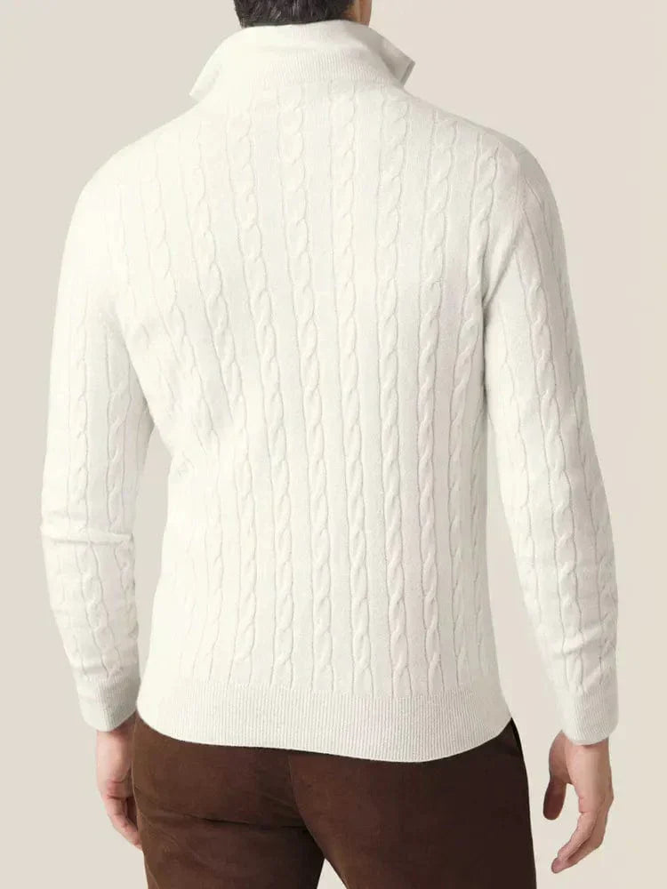 White cable knit V-neck sweater worn with a light blue collared shirt and brown pants