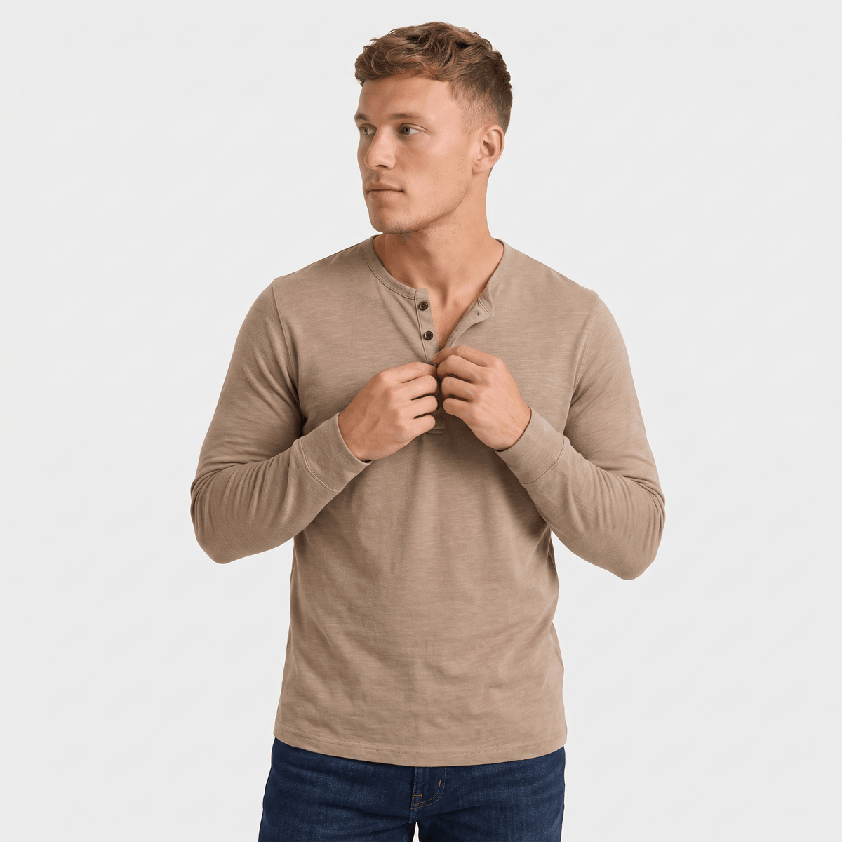Man wearing a taupe long-sleeve Henley shirt with a three-button placket, crew neckline, and tailored fit.
