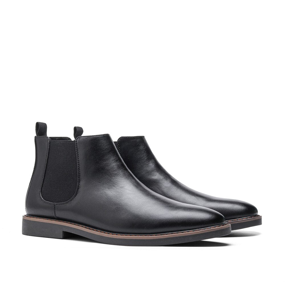 Pair of black leather Chelsea boots displayed together, showing the elastic side panels, pull tabs, and sleek silhouette.