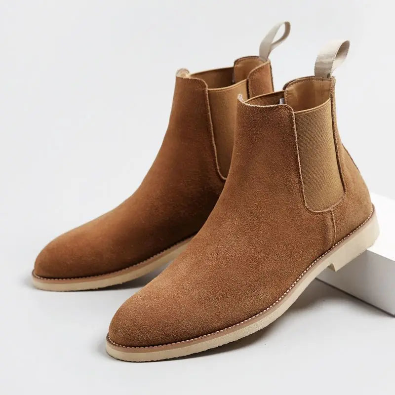 Pair of brown suede Chelsea boots displayed together, featuring elastic side panels and rear pull tabs.