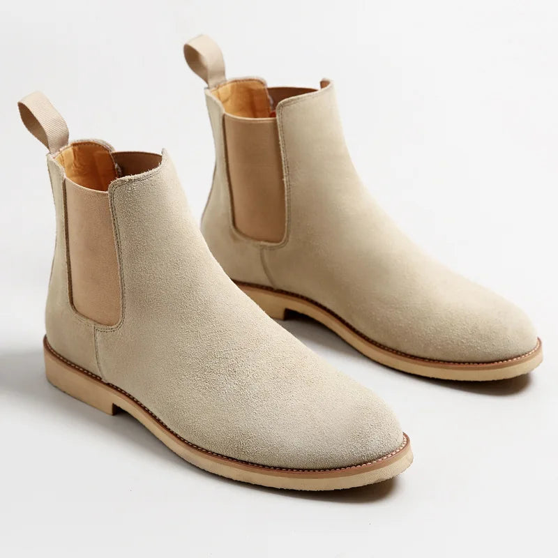 Pair of beige suede Chelsea boots with elastic side panels, pull tabs, and light-colored soles.