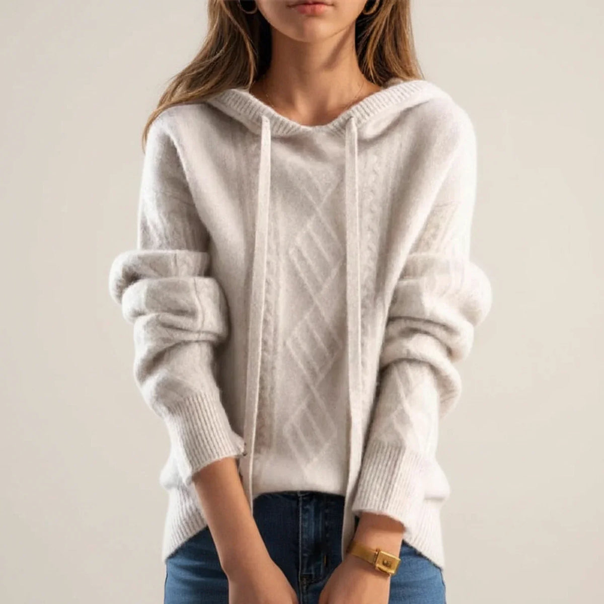 Beige hooded cable knit sweater worn by a female model, front view