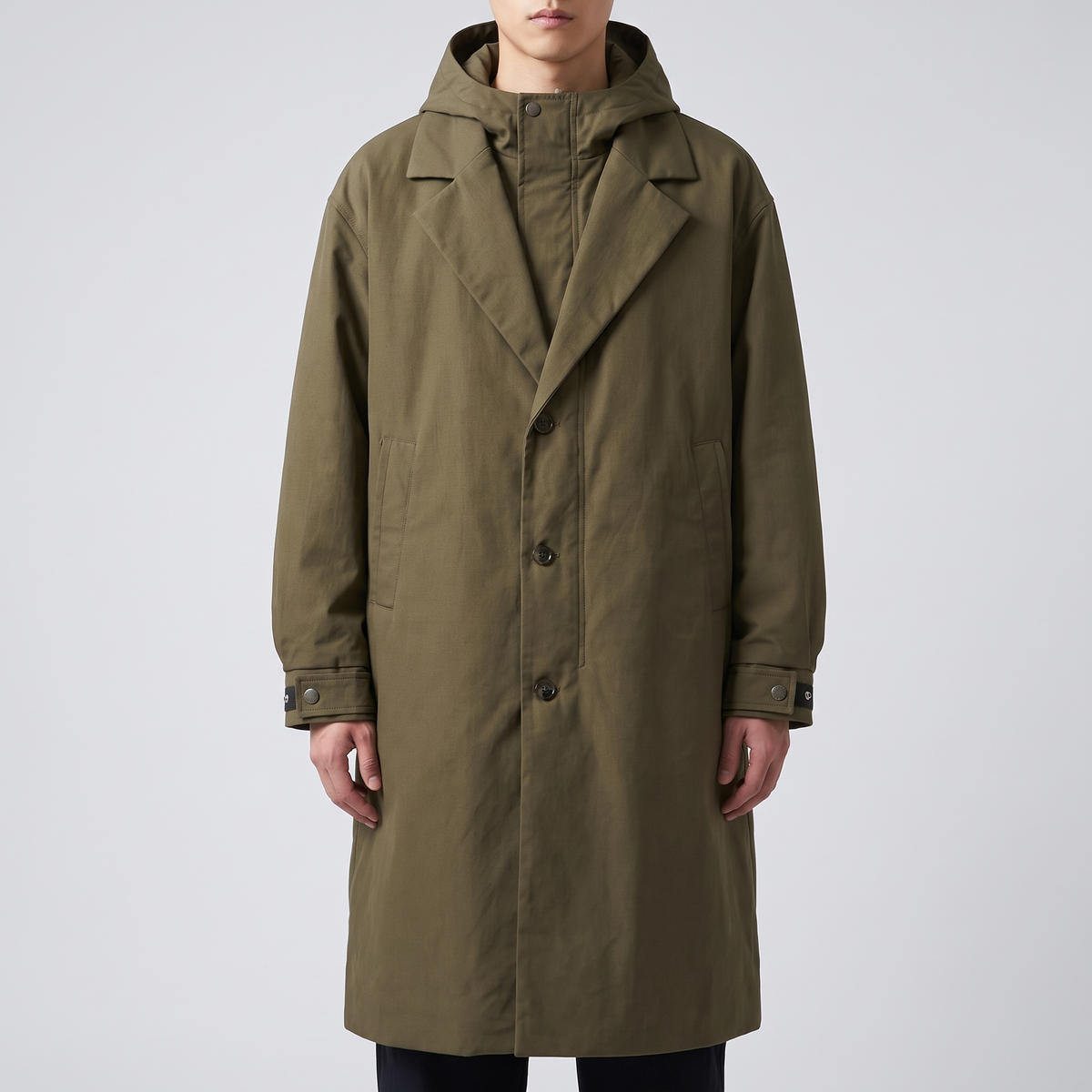 A man wearing a khaki hooded tailored overcoat with a water-resistant shell and longline fit, front view