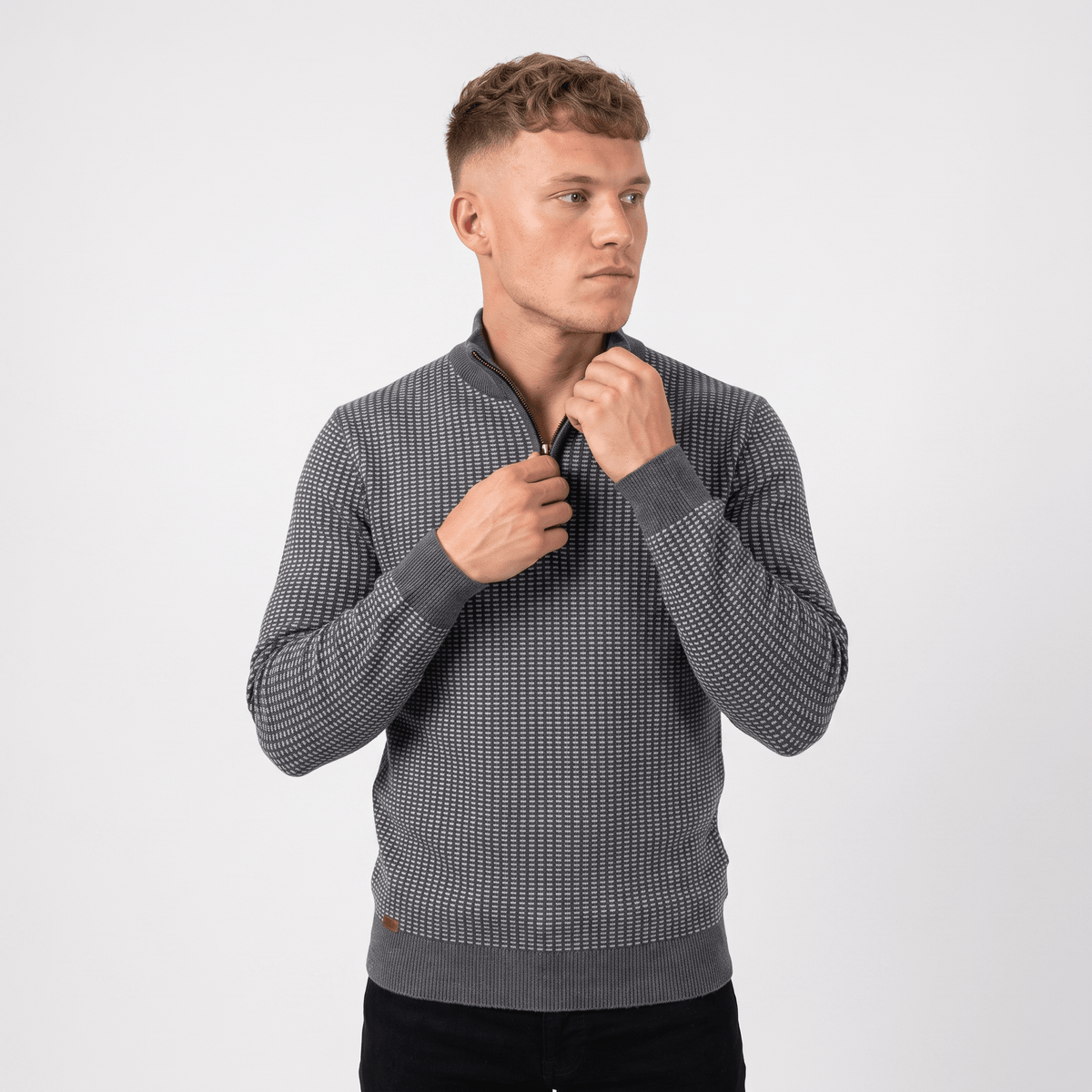 Man wearing a gray textured quarter-zip knit sweater with a stand collar, long sleeves, and a modern fitted silhouette.