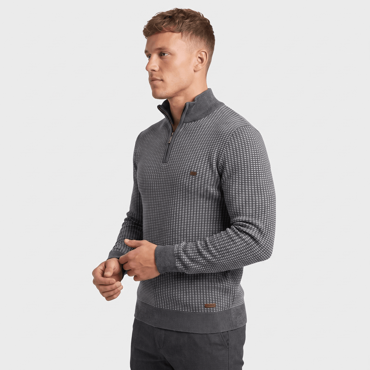 Side view of a man wearing a gray textured quarter-zip sweater featuring a stand collar and geometric knit texture.