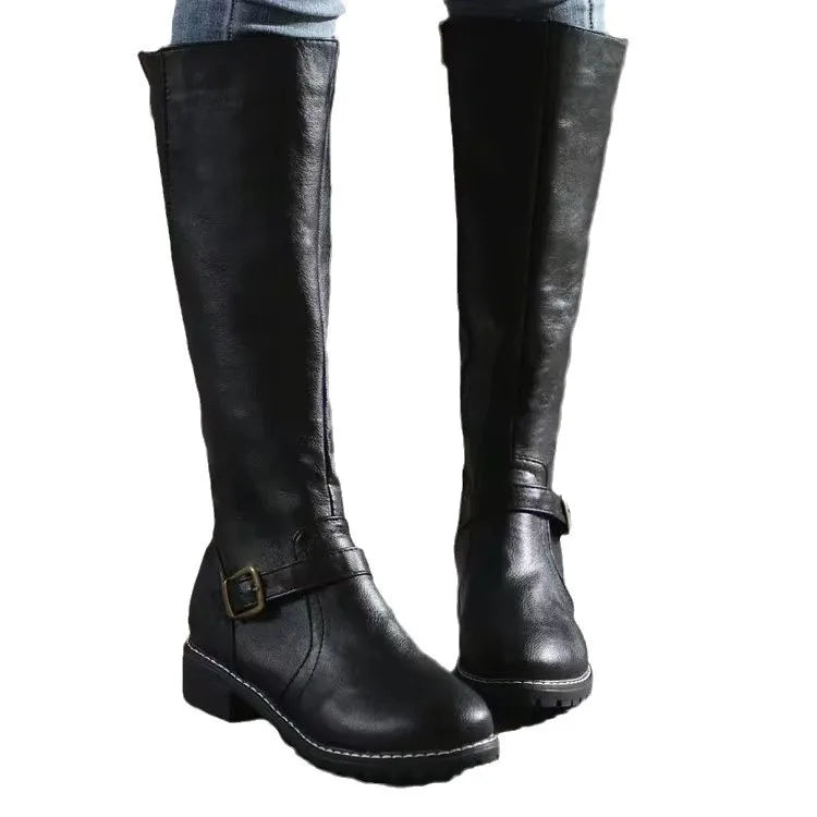 Black smooth grain knee-high riding boots with a round toe, low stacked block heel, and decorative ankle buckle strap.
