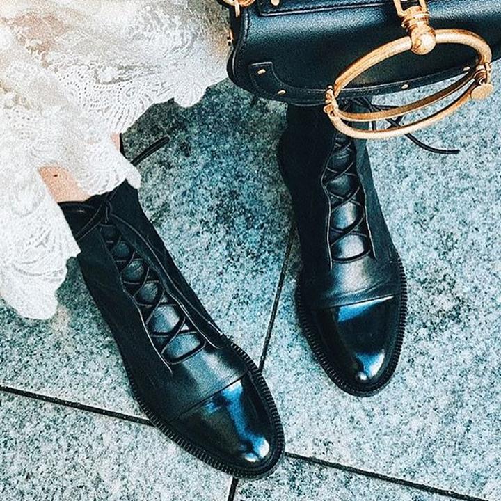 Person wearing a black leather ankle boots.