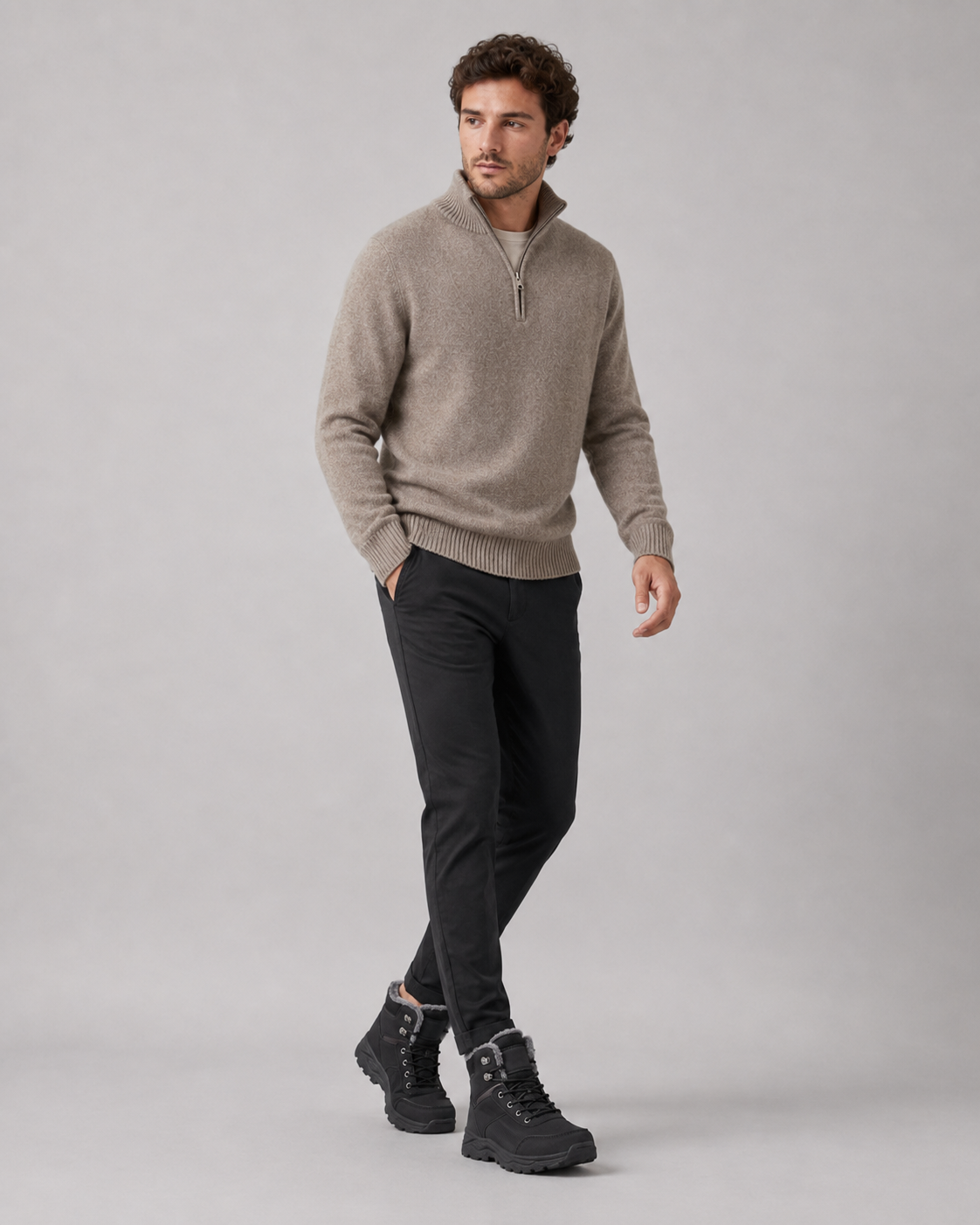 A man wearing black lace-up winter ankle boots with a plush-lined collar and lug sole, full-length view