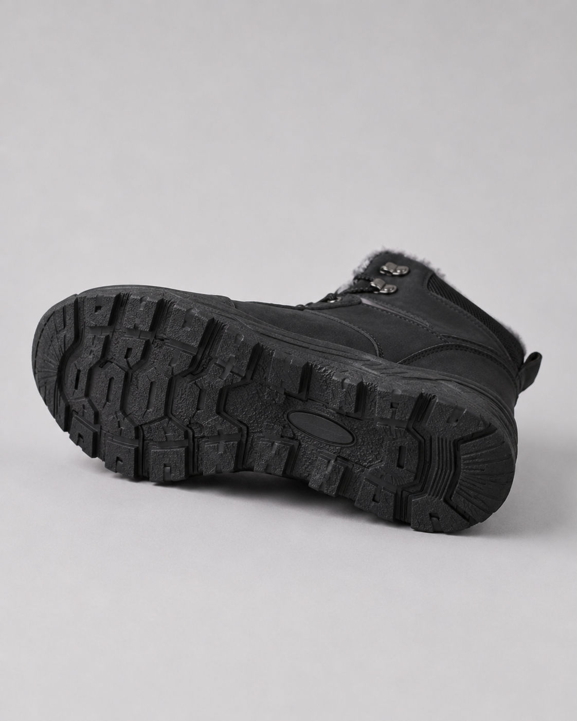 Black winter ankle boot showing the textured lug sole and lace-up design