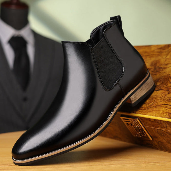 Pair of black leather Chelsea boots displayed together, featuring elastic side panels, pointed toes, and low heels.