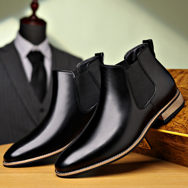 Pair of black leather Chelsea boots displayed together, featuring elastic side panels, pointed toes, and low heels.