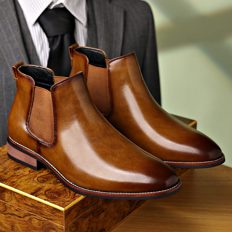 Pair of polished brown leather Chelsea boots displayed together, highlighting the elastic side panels and pointed toes.