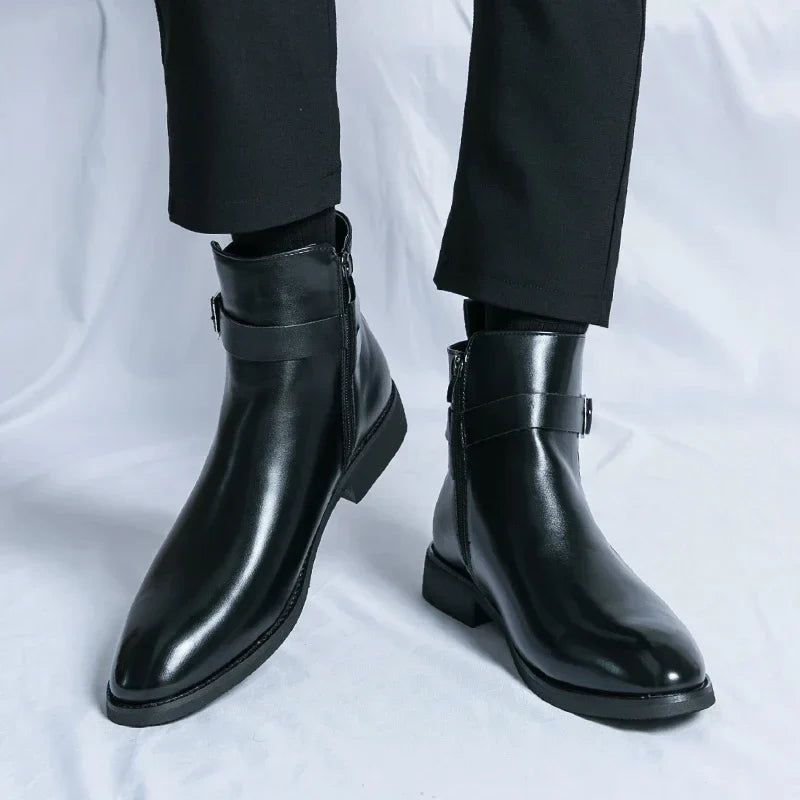 Person wearing black leather ankle boots, showing the sleek pointed toes and low block heels.