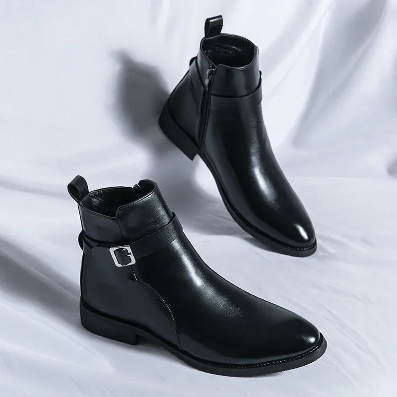 Pair of black leather ankle boots with side buckles, pull tabs, pointed toes, and block heels.