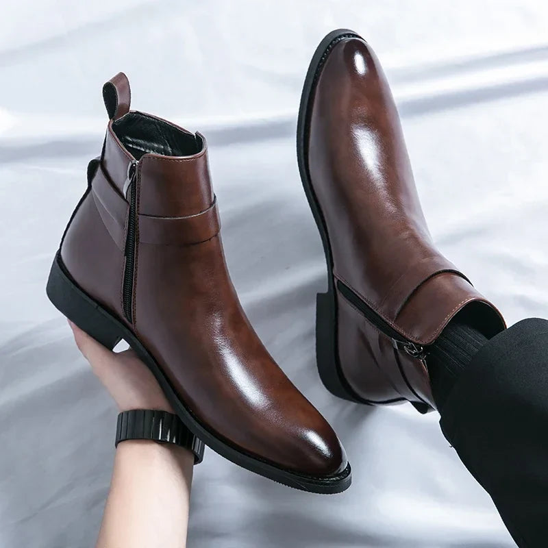 Close-up of polished dark brown ankle boots being held by a person, highlighting the buckled straps and sleek finish.