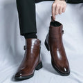Person wearing polished dark brown leather ankle boots with side buckles, pull tabs, and block heels.